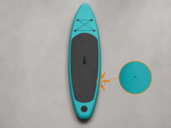 Mani con guanti che controllano un piccolo foro e una toppa su un SUP turchese